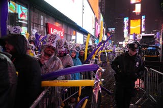Orang-orang yang bersuka ria menunggu di tengah hujan di Times Square untuk menyaksikan pesta bola tengah malam untuk merayakan Malam Tahun Baru pada 31 Desember 2024 di New York City.